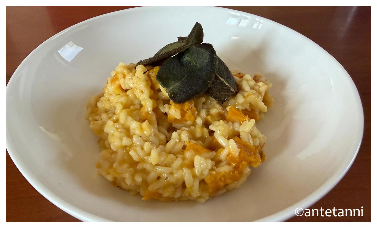 Cremiges Kürbisrisotto mit gerösteten Butternut-Würfeln und Salbeiblättern im weißen Teller